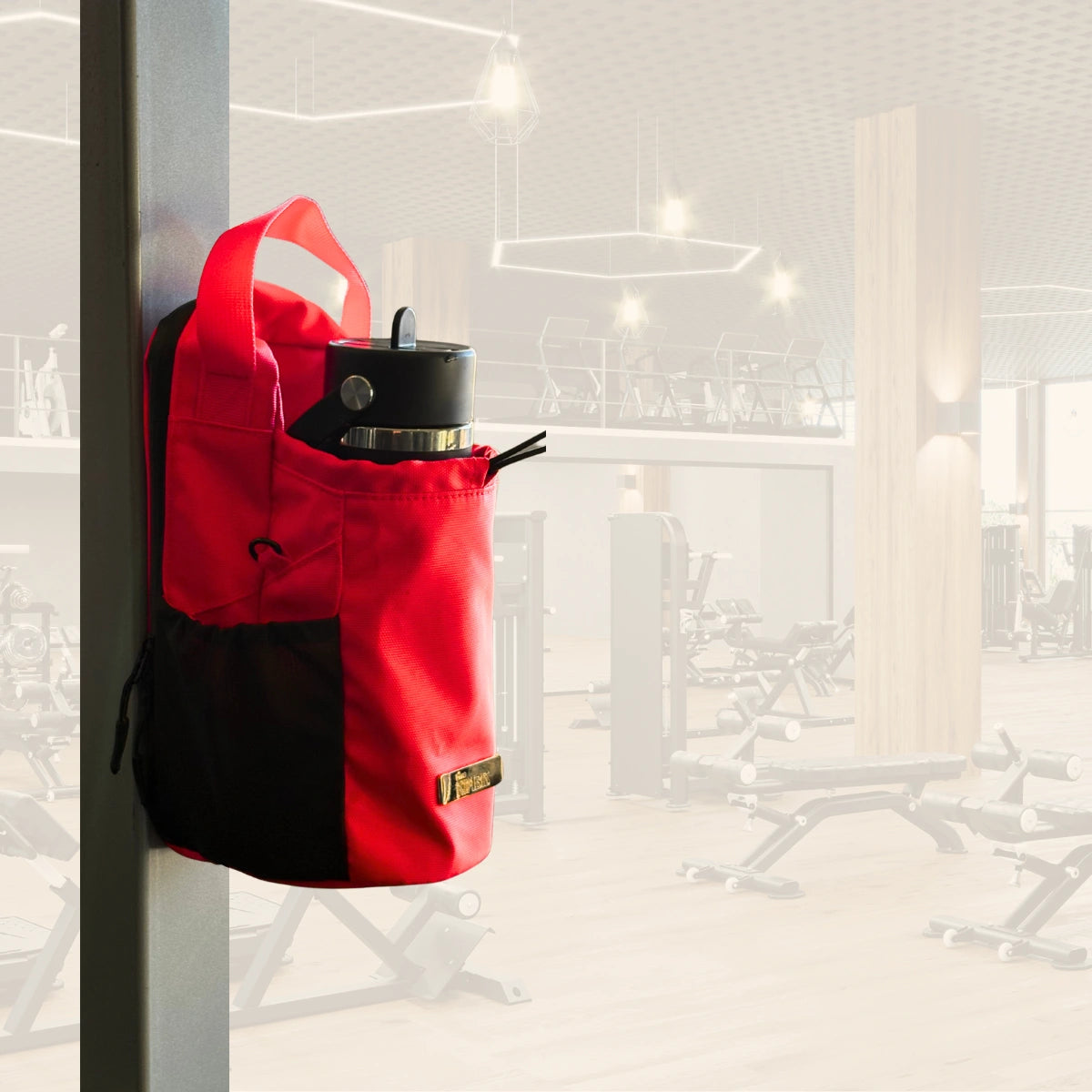 Red Nimbis magnetic gym bag attached to a metal rack in a gym, holding water bottle and accessories.
